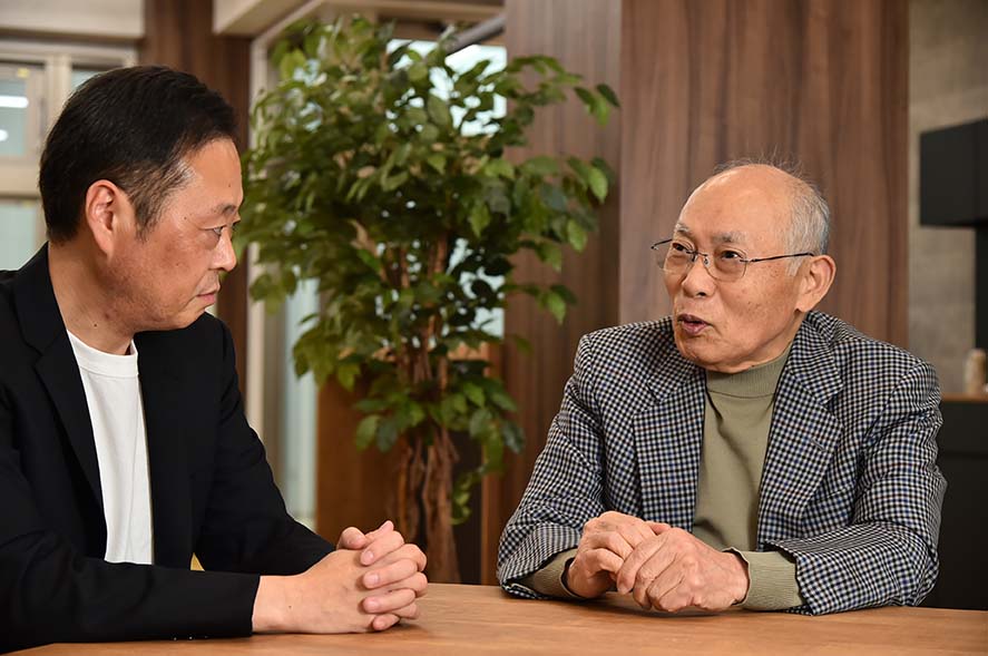 尾﨑正夫相談役会長がインタビューで語る様子